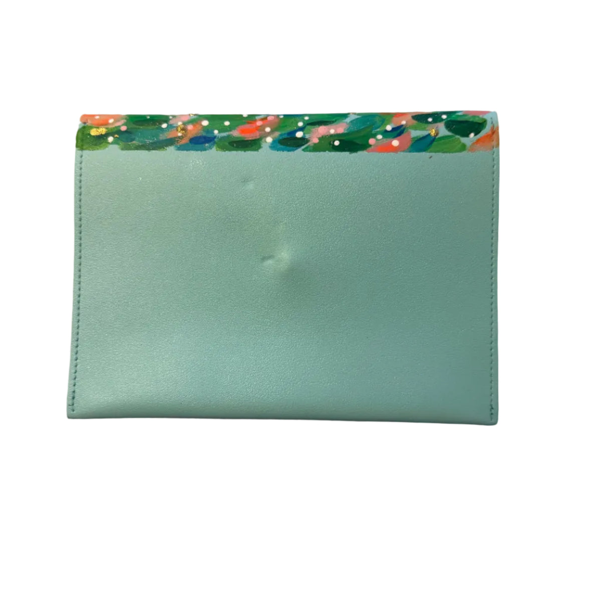 A mint green leather card holder or wallet with a colorful patterned paper trim along the top edge, placed on a white and gray marble surface.