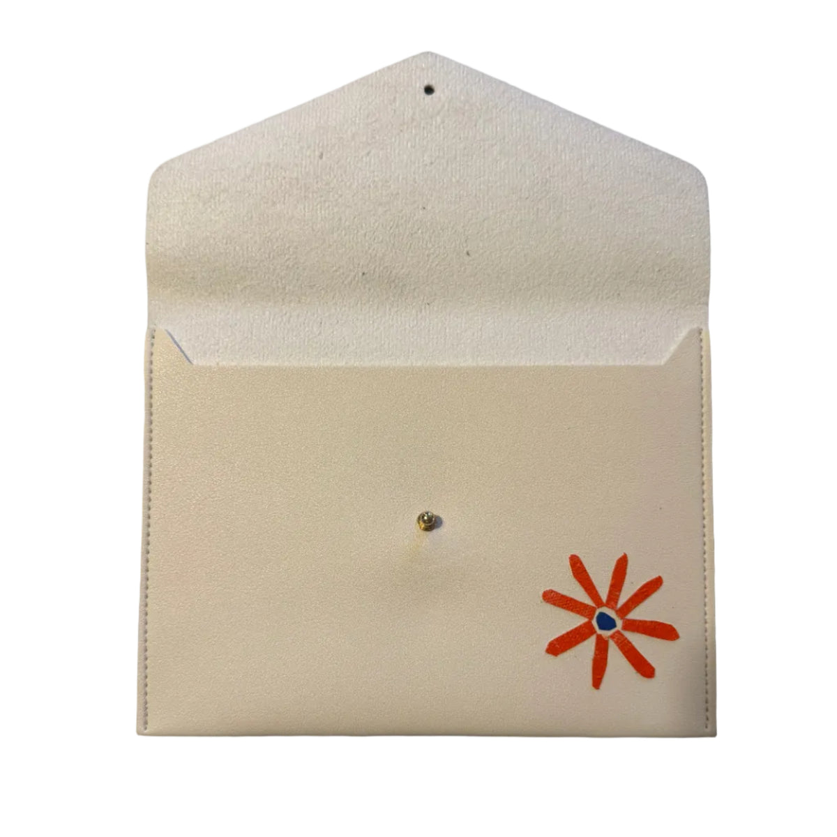 A cream-colored leather envelope or card holder with a small orange flower design and a central silver pin, displayed on a gray marble surface.
