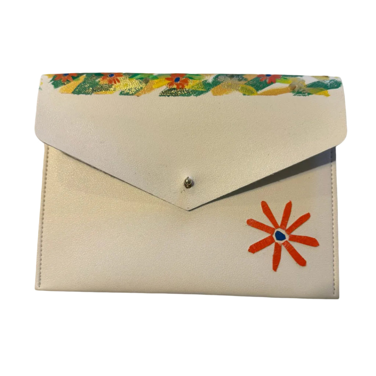 A cream-colored envelope-style clutch wallet with a colorful floral pattern along the top flap edge and a red-orange flower applique on the front, resting on a white marble surface.