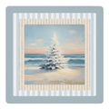 A square framed art print featuring a snowy pine tree on a beach at sunset, surrounded by layered decorative borders in light blue, cream, and white stripes.